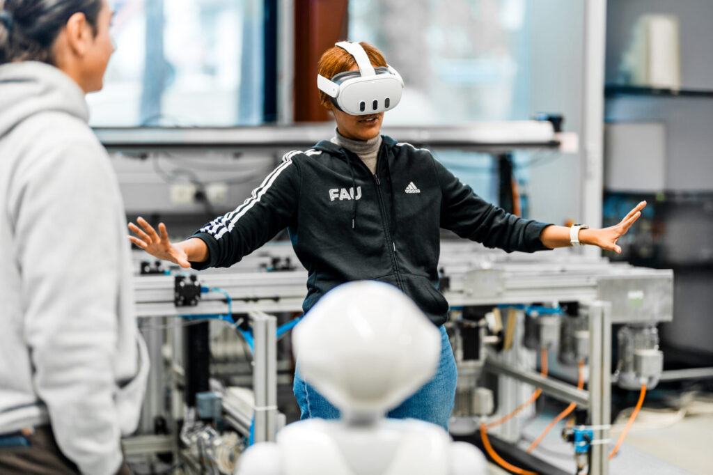 Frau und Mann mit VR Brille und Roboter in Labor.