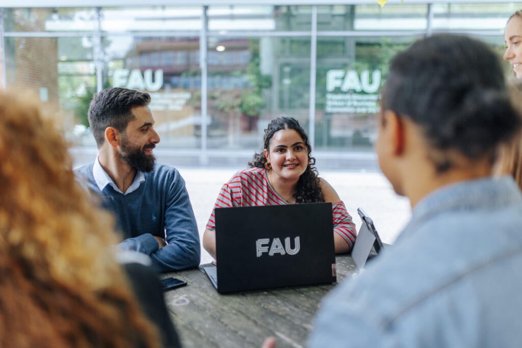 Studierende in einer Besprechung im Innenhof.