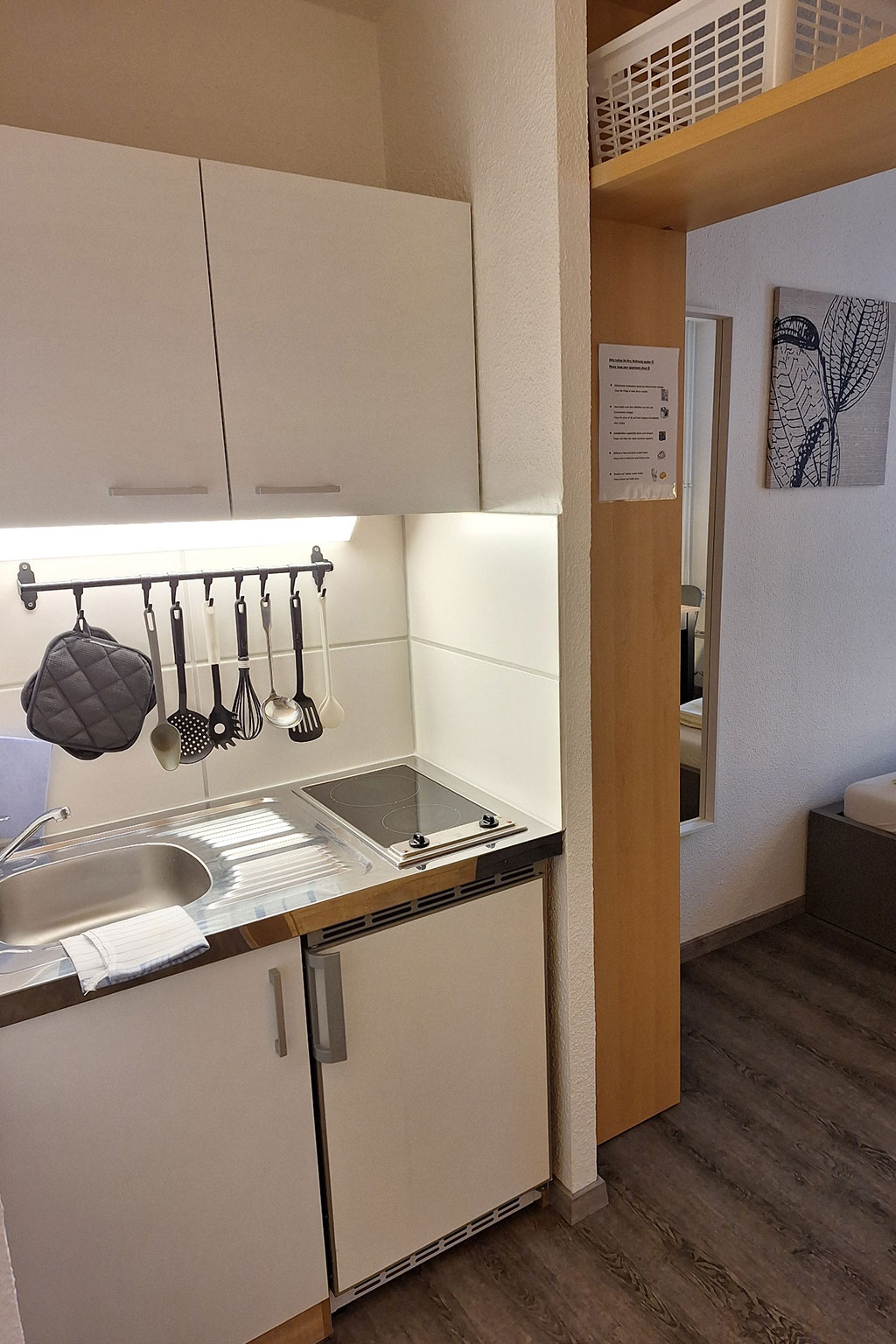 View of a kitchen with work surfaces and sink.