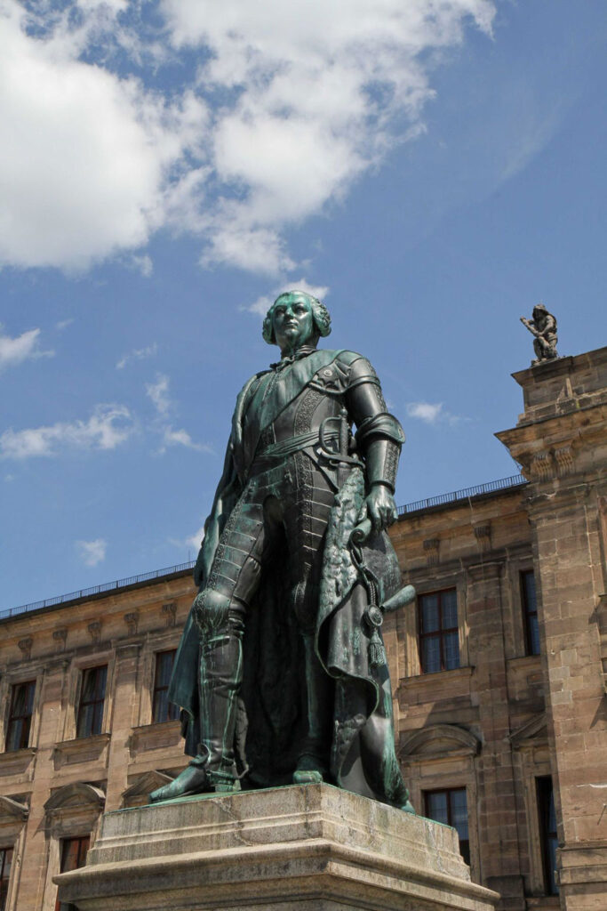 Statue des Markgrafen am Erlanger Schloss. Im Hintergrund ist das Schloss noch zu sehen.