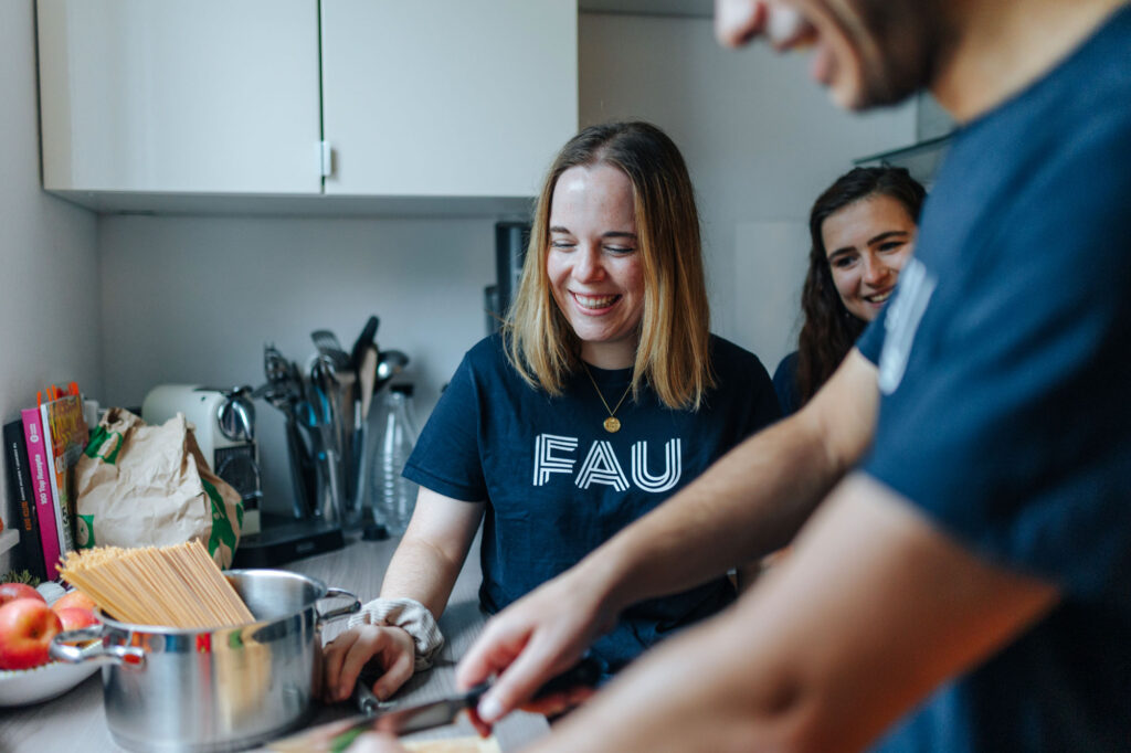 Studierende stehen in einer Küche und kochen.