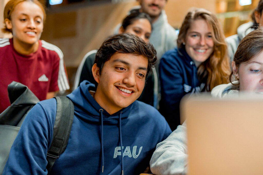 Studierende sitzen vor einem Laptop