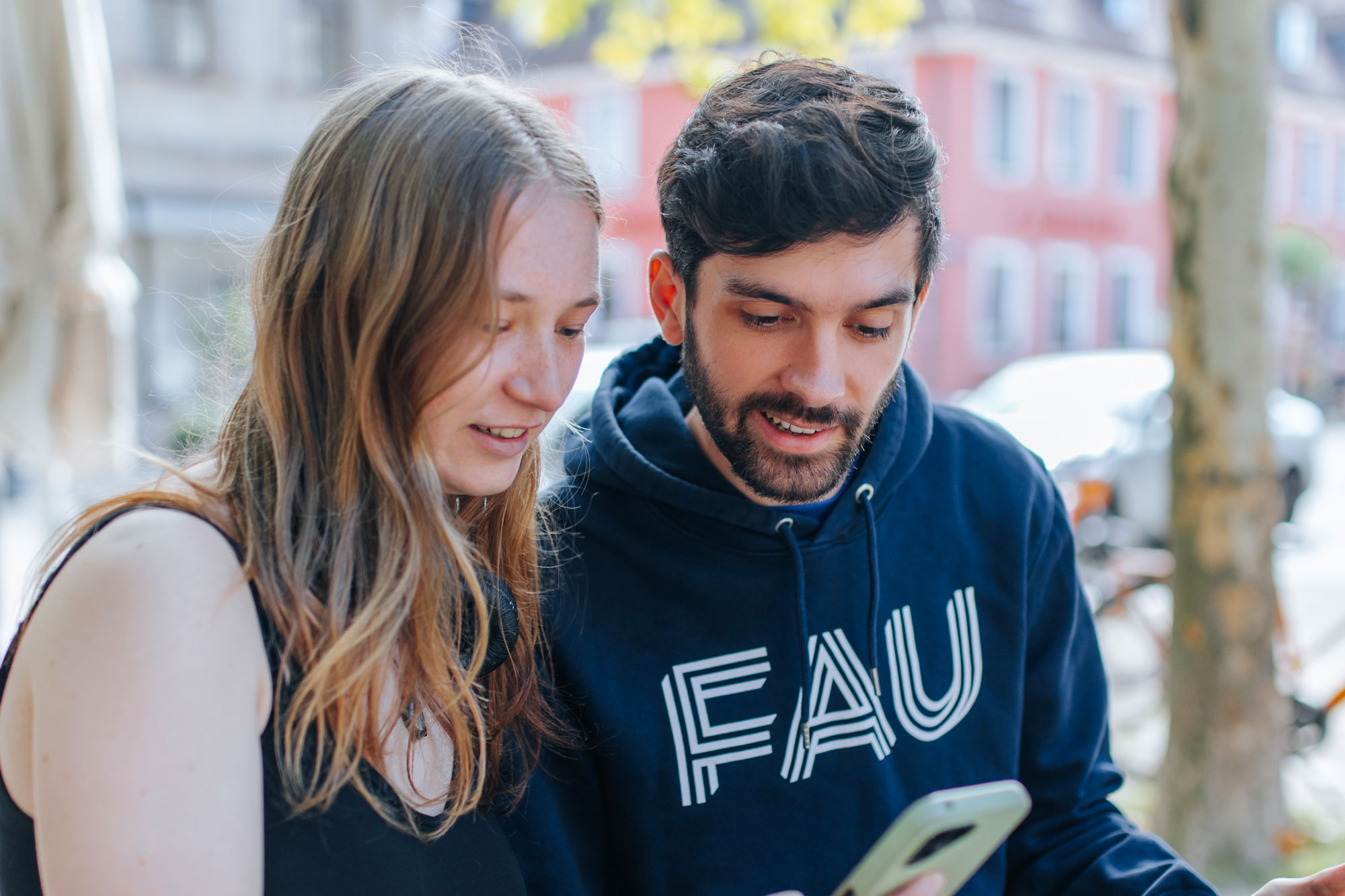 Ein Mann und eine Frau schauen auf ein Smartphone