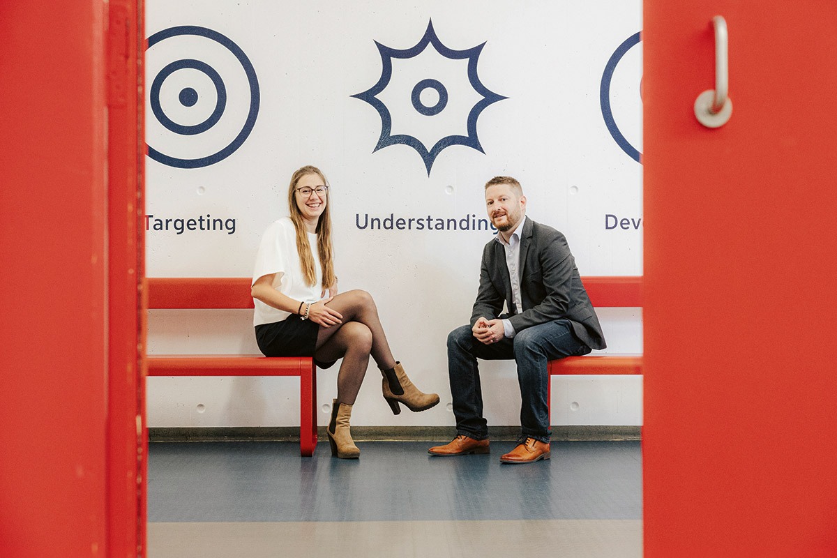 Katharina Oft und Mario Liebensteiner sitzen auf roten Bänken.