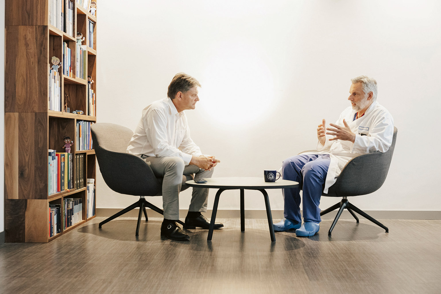 Joachim Hornegger und Oliver Schnell sitzen gemeinsam an einem Tisch und unterhalten sich.