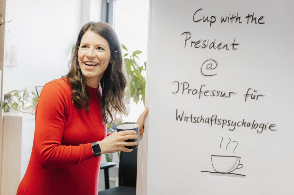 Eine Frau steht vor einem White Board.