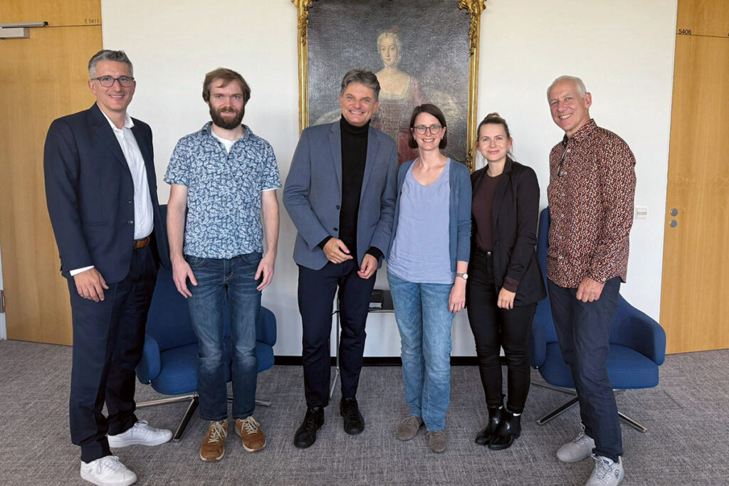 Joachim Hornegger mit einer Gruppe von Beschäftigten.