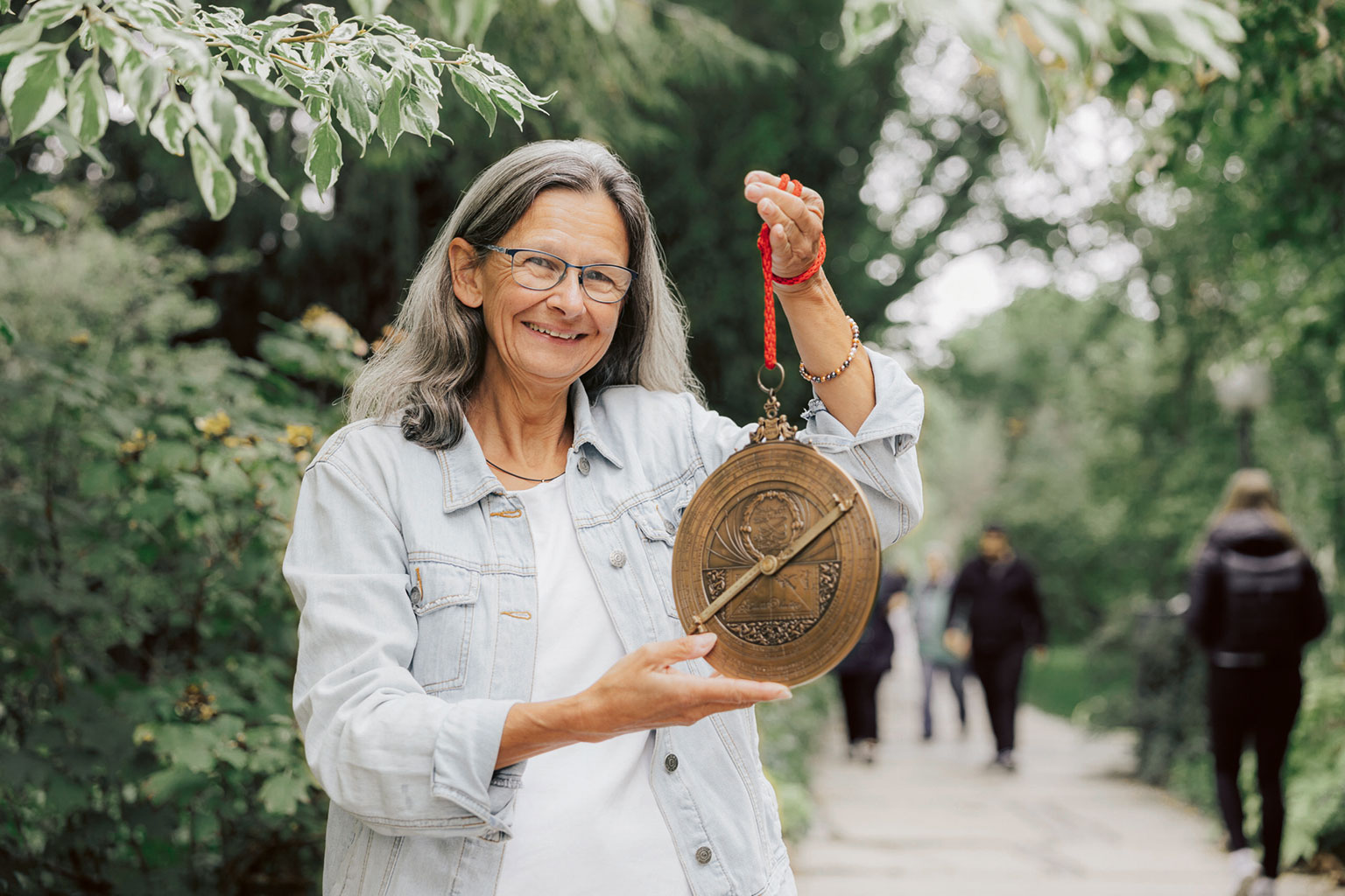 Petra Schmidl hält ein Replikat an einer roten Schnur hoch.