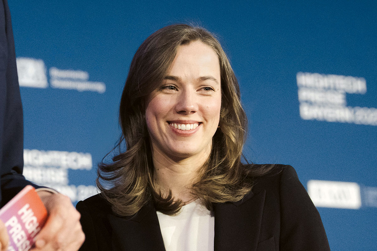 Johanna Geiß steht auf der Bühne und grinst in das Publikum.