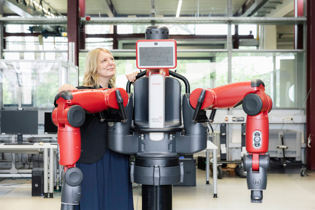 Cornelia Niessen mit einem roten Roboter.
