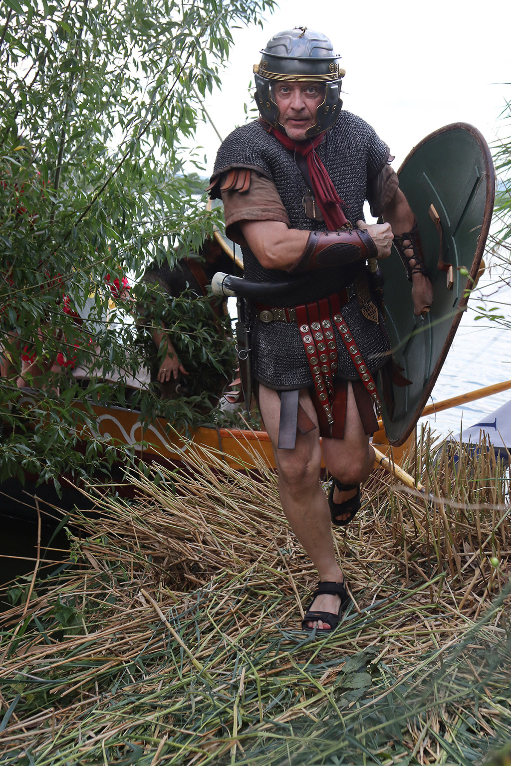 Ein Mann in römischer Soldatenrüstung zieht rennend ein Schwert.