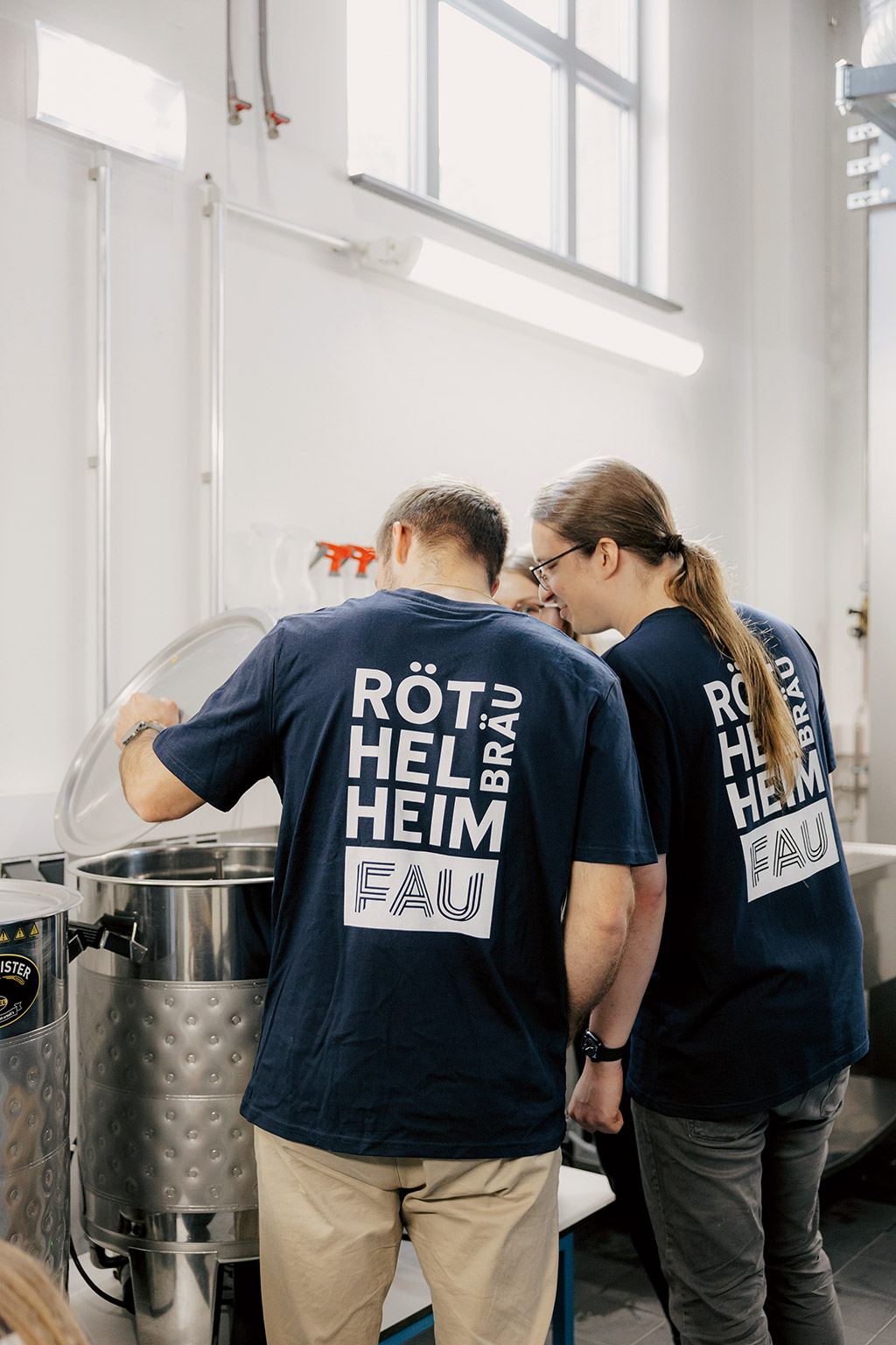 Zwei Studierende schauen in einen Kessel.