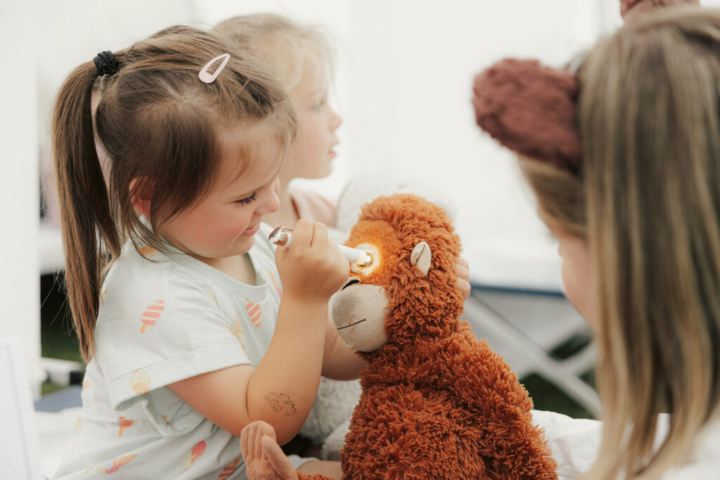 Ein Kind untersucht seinen Plüschaffen.