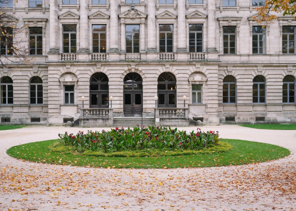Sicht auf ein Blumenbeet vor einem alten Gebäude.