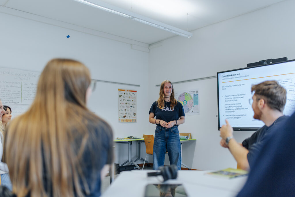 Drei Personen unterhalten sich im Seminarraum.