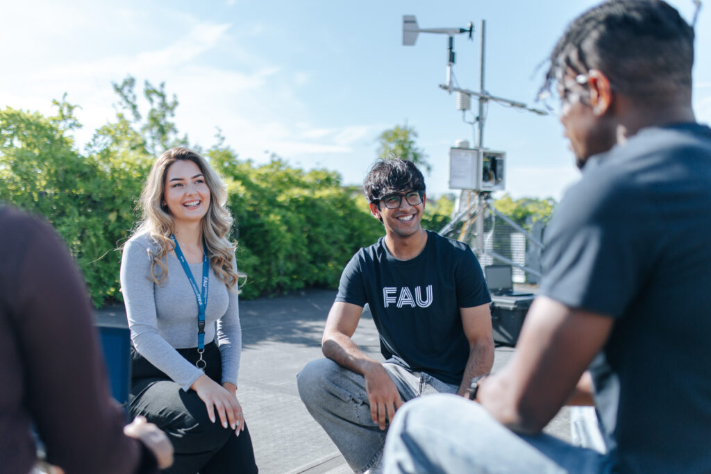 Studierende besprechen sich auf einer Dachterrasse.