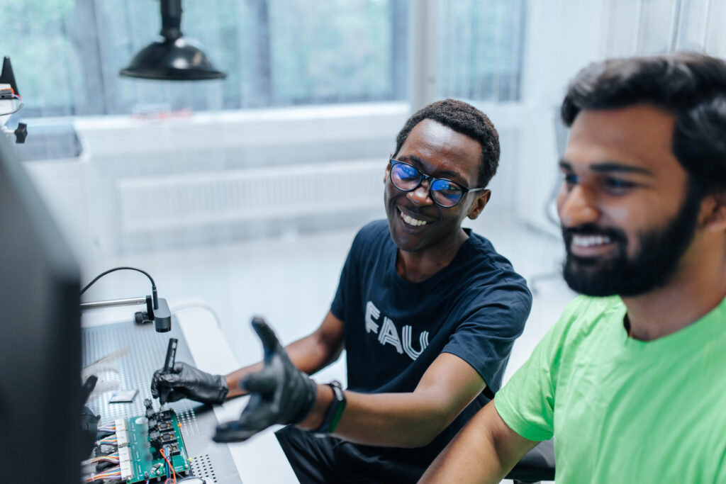 Zwei personen arbeiten an einem Werktisch.