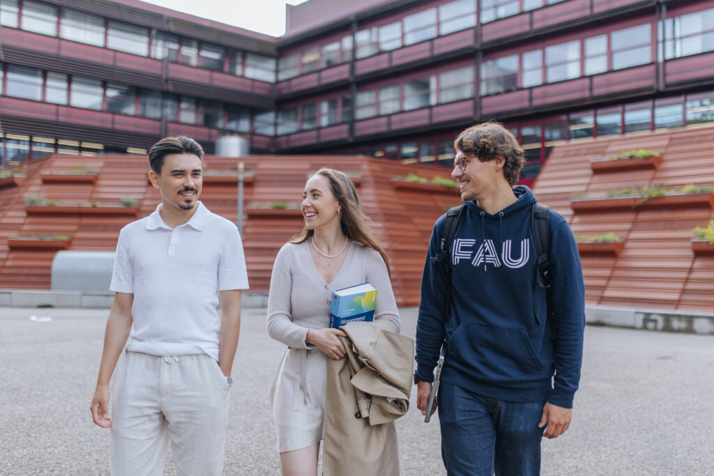 Drei Personen laufen in in einem Innenhof.