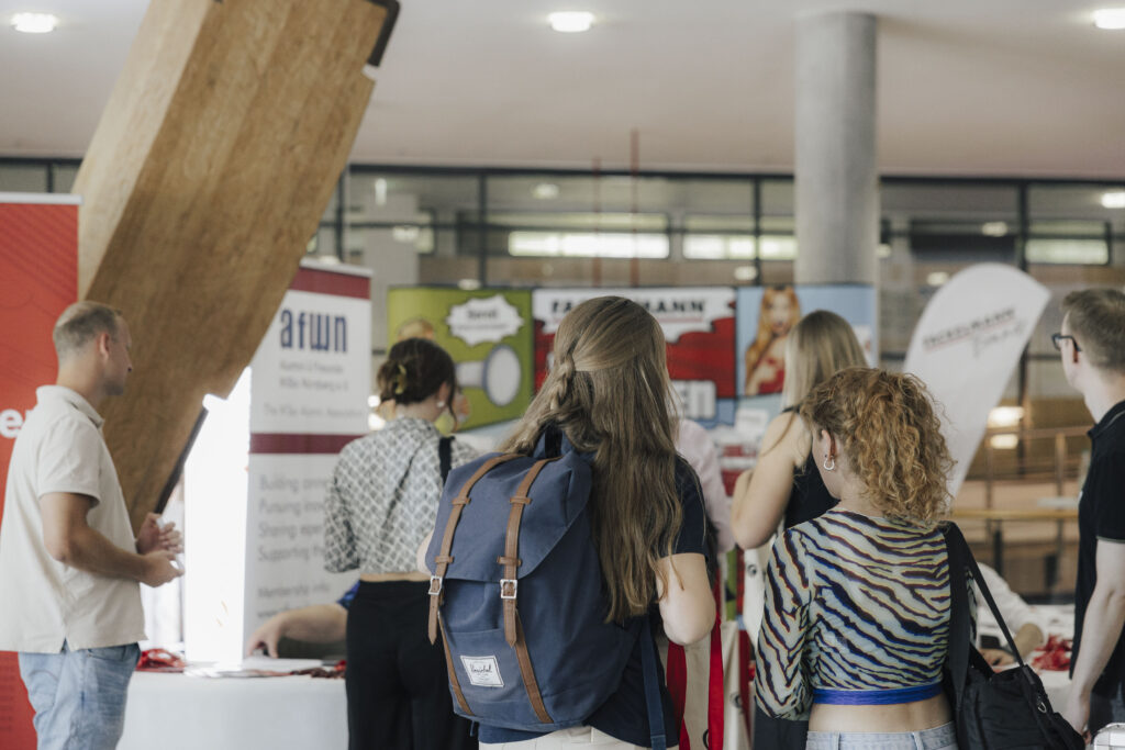 Personen, die eine Messe im Foyer der Langen Gasse besuchen.
