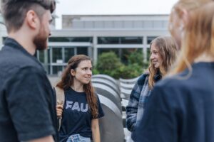Studierende vor dem Gebäude der Philosophischen Fakultät und Fachbereich Theologie der Friedrich-Alexander-Universität Erlangen-Nürnberg (FAU)