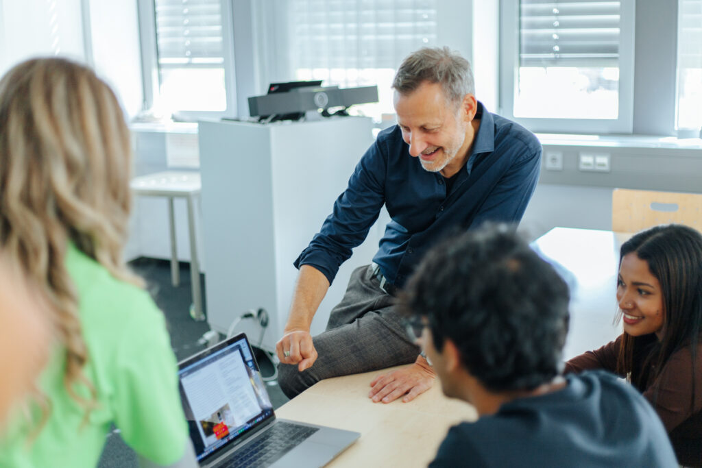 Ein Mann erklärt etwas am Laptop