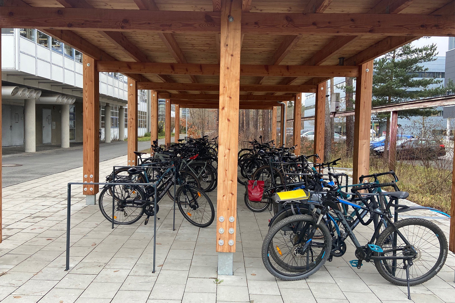 Fahrräder an Bügeln angeschlossen unter Dach aus Holz