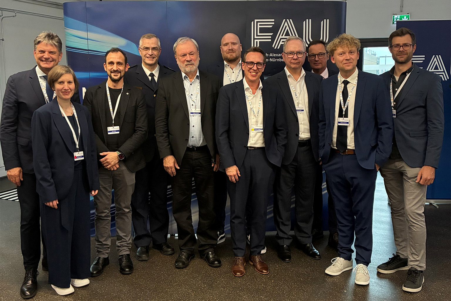 Gruppenfoto vor FAU-Logo