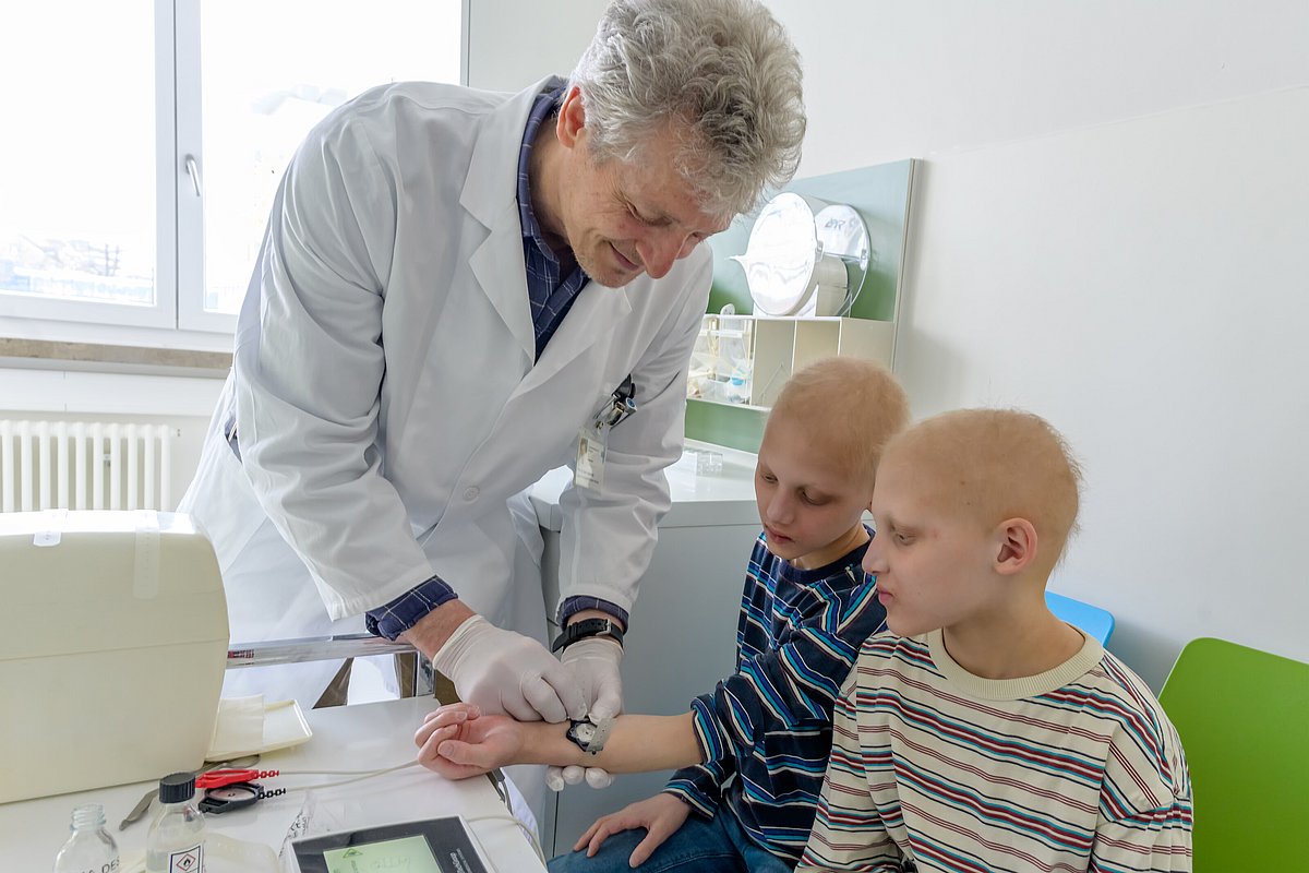 FAU Prof. Dr. Holm Schneider misst Anfang 2026 das Schweißvolumen am Unterarm der Zwillinge: alles wie bei gesunden Kindern!