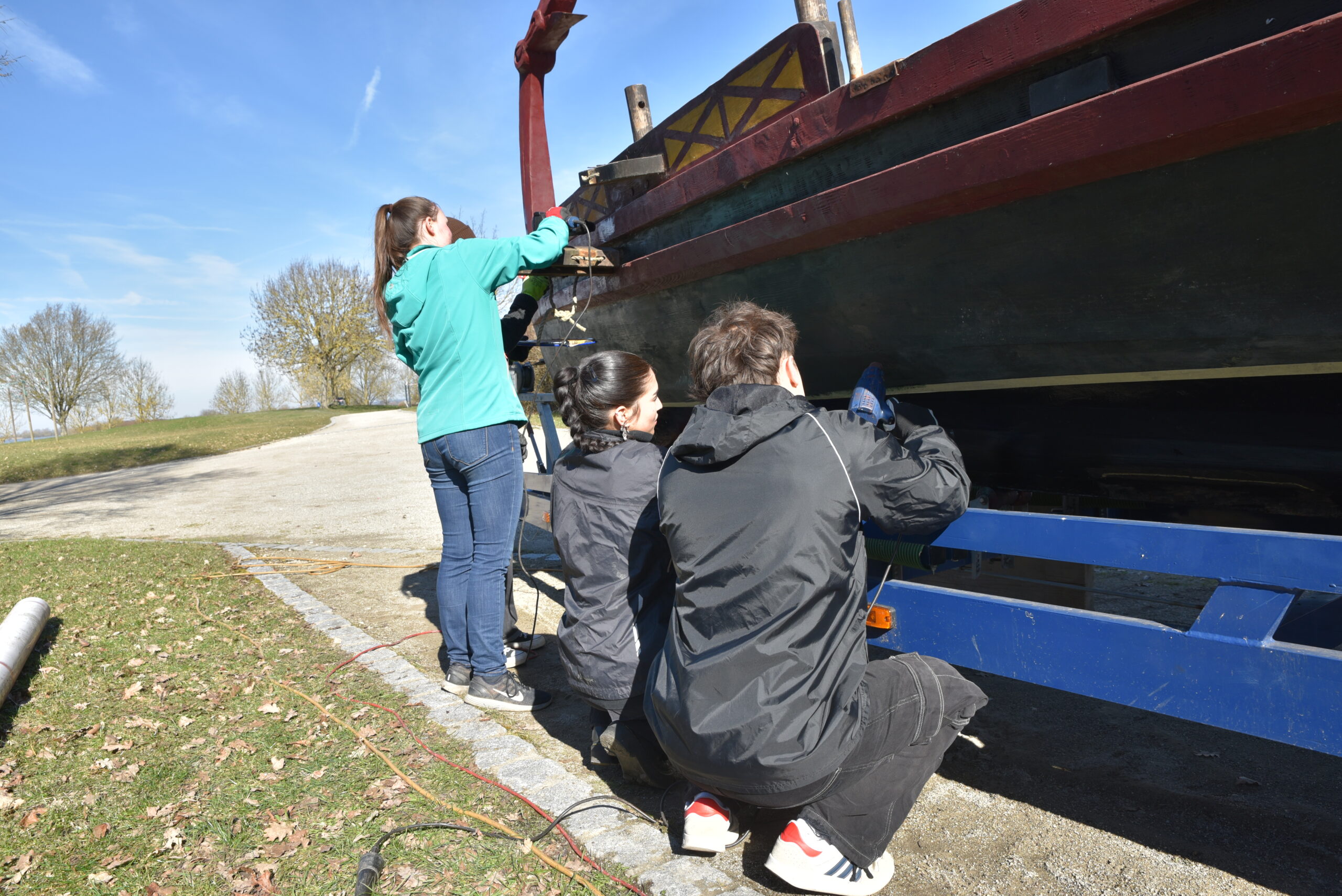Students studying for a teaching degree in Chemistry paint FAU’s first Roman boat.