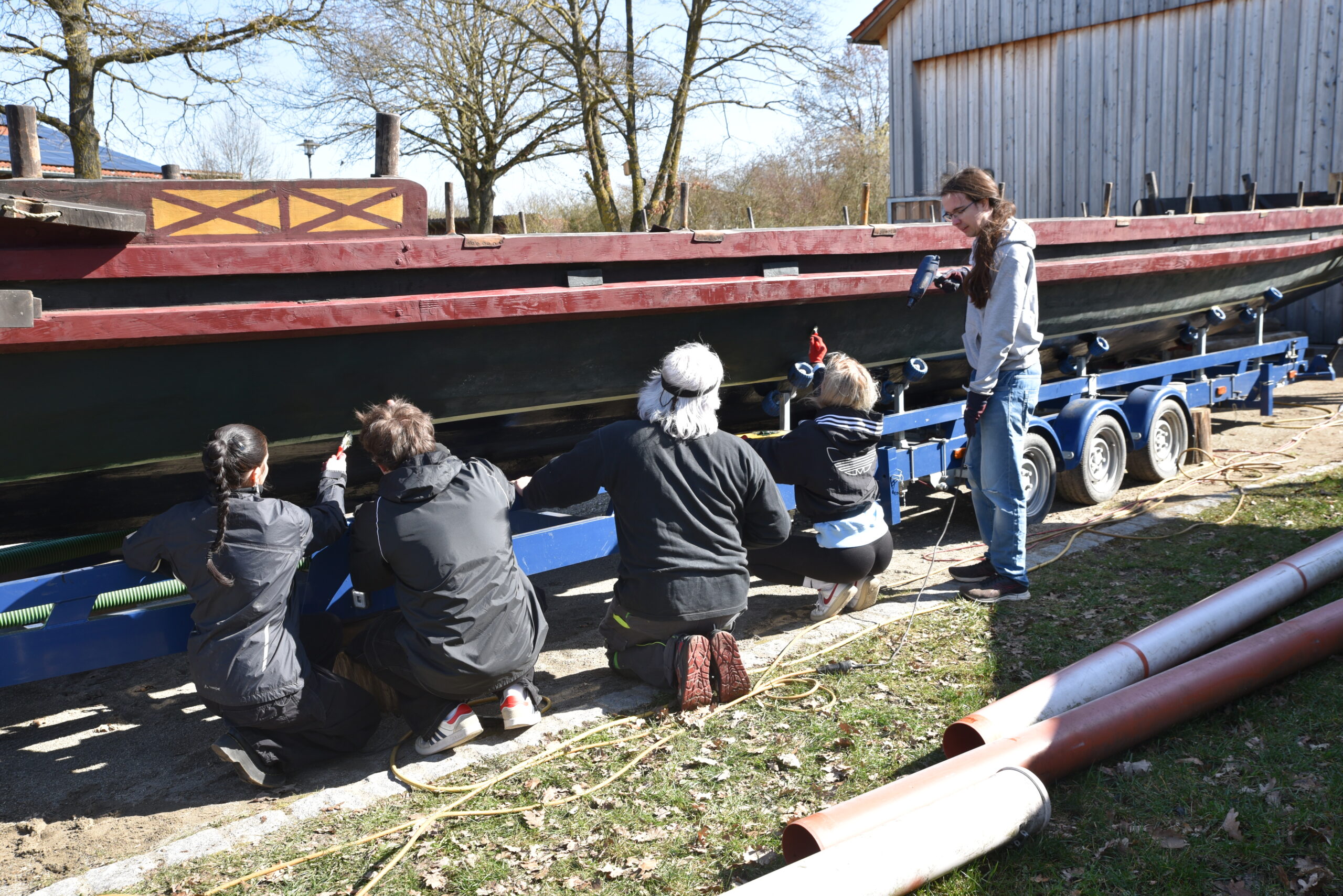 Students and supervisor Dr. Marcus Speck (middle) paint FAU’s first Roman boat.