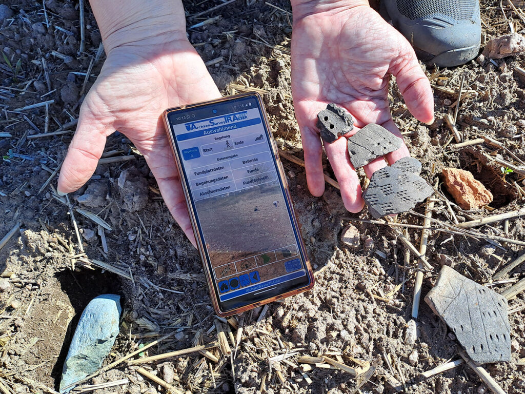 Scherben und andere archäologische funde und ein Handy mit der App.