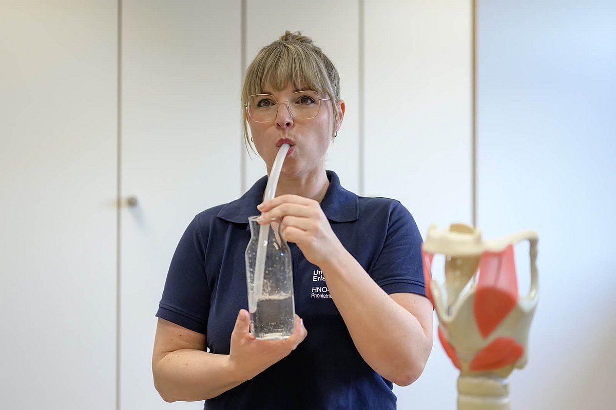 Mit einem Schlauch im Wasser blubbern und dadurch die Stimmbänder massieren: Diese Übung hilft bei Heiserkeit und Stimmermüdung. Zugleich eignet sie sich ideal als Warm-up für Sängerinnen wie Jessica Herzog