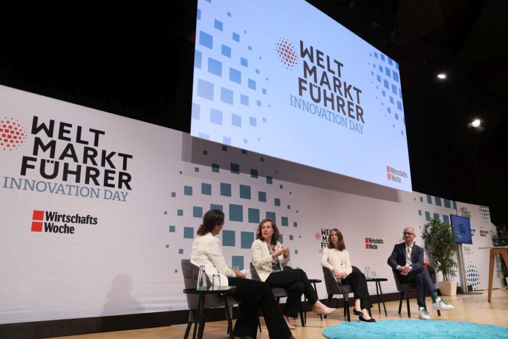 Auf einer Bühne unterhalten sich vier Personen zum Weltmarktführer Innovation Day.